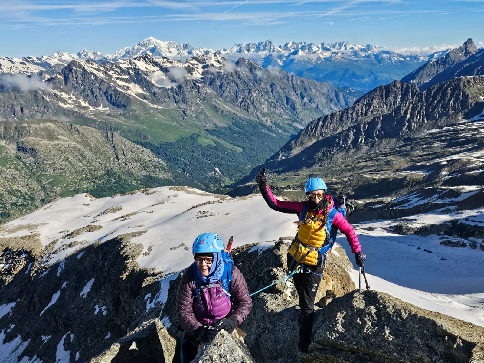 Mountaineers climbing a snowy, sunny mountain.