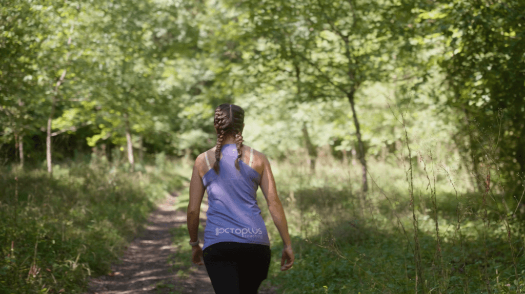Femme marchant sur chemin forestier