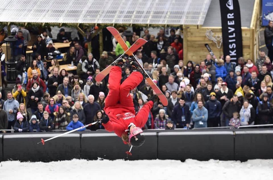 Skieur en tenue ESF fait une figure acrobatique.