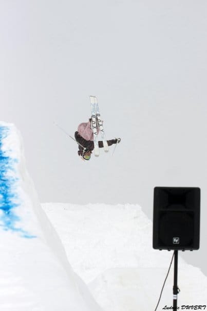 Skieur effectuant un saut acrobatique dans la neige.